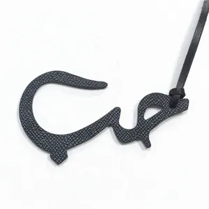 Détail de breloque de sac en cuir véritable noir lettre arabe, pendentif élégant pour sac femme auto.