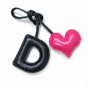 Handmade leather letter D charm with pink heart detail for bags and car hanging pendants.