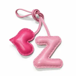 Leather pink heart and letter Z bag charm detail showing neat handmade stitching and texture.