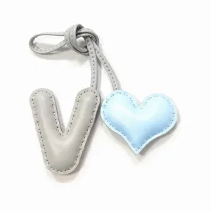 Hermoso colgante de bolso de cuero artesanal con letra V y corazón accesorio elegante.
