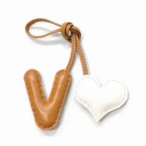 Dije de bolso de cuero hecho a mano letra V y corazon colgante elegante para cartera.