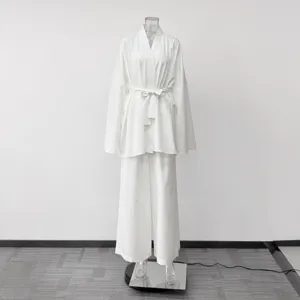 White loungewear set detail showing long sleeve wrap cardigan and matching wide leg trousers.