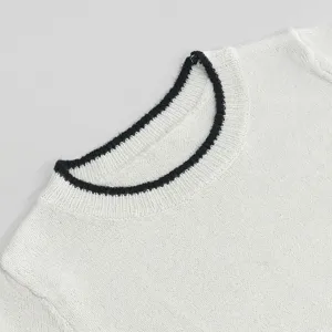 Nahaufnahme des weißen Strickpulloverkragens mit Rippstruktur, elegantes minimalistisches Detail.