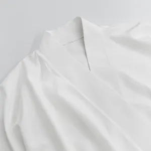 Detailed close-up shot of the white loose solid color cross-collar lounge wear cardigan neckline.