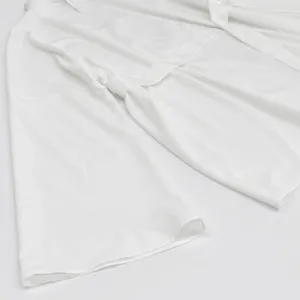 Close-up detail of a solid white long sleeve cardigan top with a tie belt, soft fabric.