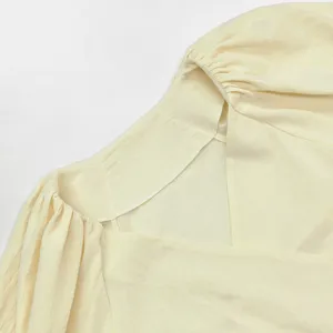 Französischer Stil Puffärmel tief V-Ausschnitt Kleid Detail Nahaufnahme, cremefarben.