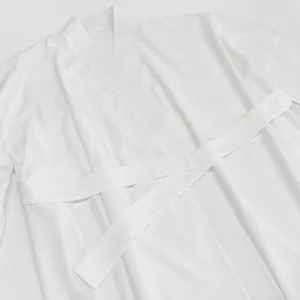 Detail view of a soft white tie-front cardigan loungewear robe, showing fabric texture.
