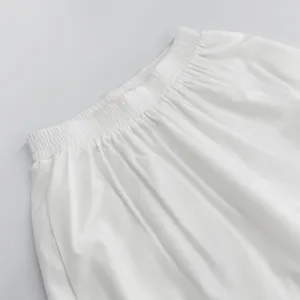 White casual pants detail showcasing comfortable elastic waistband and soft fabric texture.