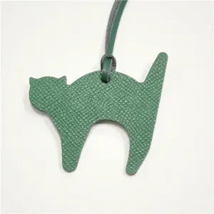 Green leather cat bag charm detail close up, cute animal pendant accessory for women handbags.