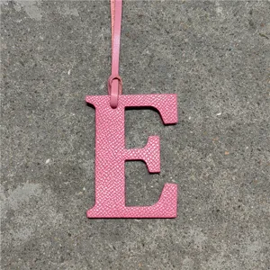 Pink leather letter E bag charm close-up detail, stylish alphabet accessory for handbags