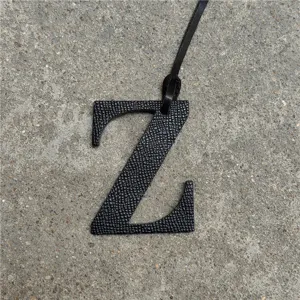 Detalle de dije de bolso con letra Z de cuero negro, elegante colgante para bolsos.