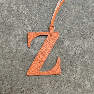 Detalle de dije de bolsa letra Z de cuero naranja, colgante de alfabeto elegante para bolsos.