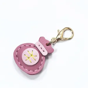 Llavero de bolsa de la suerte de cuero genuino rosa hecho a mano con mosqueton dorado.