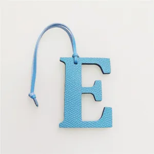 Blue leather letter E bag charm pendant detail, stylish accessory for daily handbags.