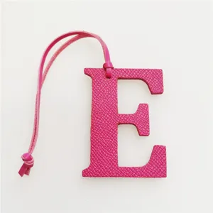 Pink leather letter E bag charm with strap, stylish alphabet pendant for handbags and keys.