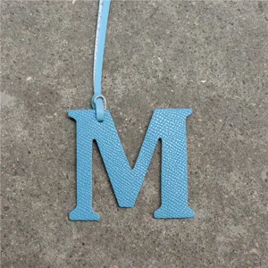 Blue leather letter M bag charm accessory, stylish alphabet pendant for purses and car keys.