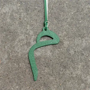 Green textured leather letter shape bag charm detailed view, stylish pendant accessory.