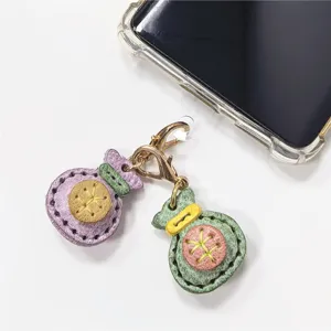 Detalle colgante teléfono bolsita de la suerte en cuero artesanal, mini accesorio dulce.