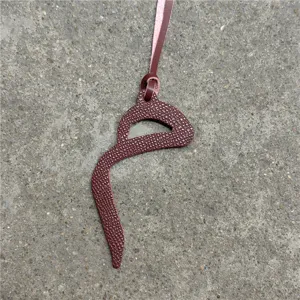 Leather bag charm detail showing fine grained texture and neat edge stitching finish.