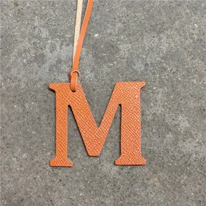Orange leather letter M bag charm chic alphabet keychain purse accessory for women style.