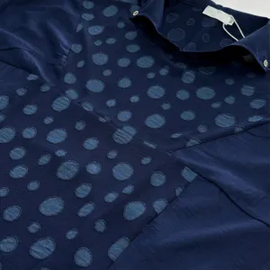 Détail de chemise à manches courtes bleu foncé, tissu jacquard à pois exquis avec col élégant.