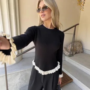 Schwarzer Langarm-Strickpullover mit kontrastierendem weißem Rüschensaum für Damen.