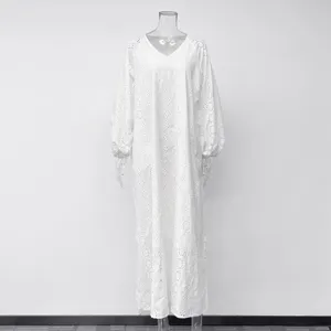 Detail de robe longue brodee evidee blanche, style elegant de couverture de plage d'ete.
