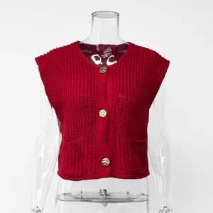 Detailed view of red chunky knit sleeveless vest featuring gold buttons and front pockets.