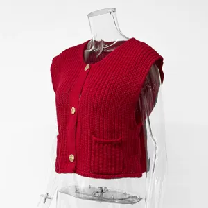 Detailansicht der roten grobgestrickten ärmellosen Strickjacke mit goldfarbenen Knöpfen und Taschen.