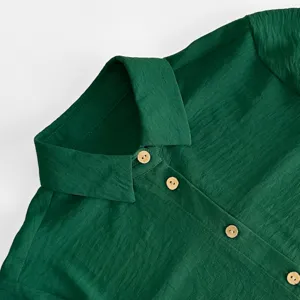 Dunkelgrüner Kleiderkragen Detail mit Holzknöpfen, elegantes und schlichtes Casual Design.