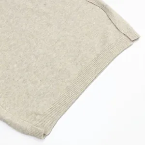 Primer plano detallado que muestra el suave tejido de punto beige y su dobladillo acabado.