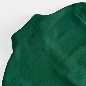 Nahaufnahme des dunkelgrünen Damenkleid-Kragens mit feiner Stofftextur im eleganten Stil.