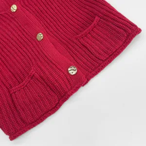 Rote grobe Strick-Ärmellose Strickjacke Detail, strukturierter Stoff mit goldenen Knöpfen.