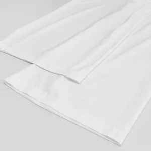 White casual loungewear pants hem detail, soft fabric, comfortable loose fit for daily wear.