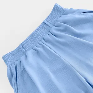 Light blue casual pants elastic waist detail closeup, soft textured fabric trouser design shot.