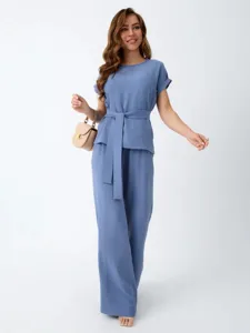 Detailed view of women casual two-piece set, featuring a loose blue top with belt and matching pants.
