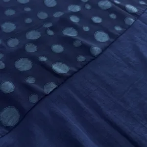 Vue détaillée de la texture de tissu à pois bleu foncé pour ensemble de vêtements.
