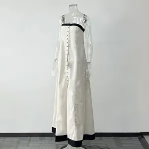 Detailed view of the elegant linen maxi dress featuring black trim and buttons.