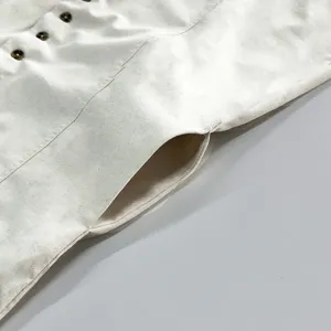 Close-up detail shot of casual linen dress showing button placket and side pocket construction.
