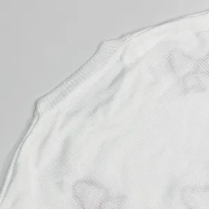 Nahaufnahme der Schulter und des Kragens eines weissen Strickpullovers mit feiner Textur.