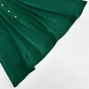 Elegantes einfarbiges grünes Kleid Detail mit feiner Textur und schicken Knöpfen für den Sommer.