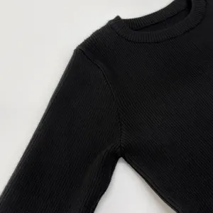 Nahaufnahme eines schwarzen gerippten Langarm-Strickpullovers mit feiner Textur und gutem Material.
