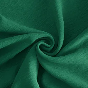 Dunkelgrüner einfarbiger Stoff Detail Nahaufnahme mit weicher Textur und eleganter Drapierung.