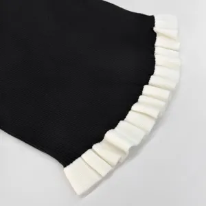 Detailansicht Damen Langarm Strickpullover mit kontrastierender weißer Rüschenmanschette.