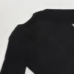 Detailaufnahme eines schwarzen Rippstrick-Pullovers, weicher strukturierter Stoff für Herbst.