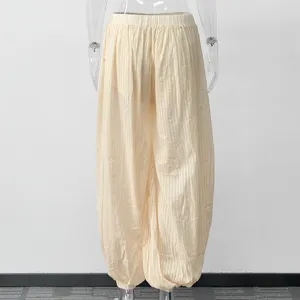 Details of casual lightweight beige balloon pants featuring high waist and elastic cuffs.