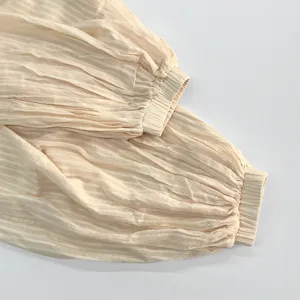 Summer casual balloon pants fabric detail, lightweight pleated texture, breathable loose fit.