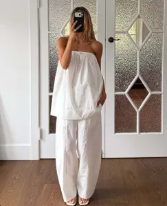 Κομψό γυναικείο καλοκαιρινό σετ λευκό strapless τοπ και μακρύ παντελόνι για διακοπές.