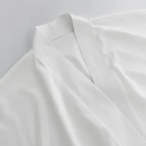 Primo piano dettaglio del colletto della veste cardigan lunga casual da donna bianca, tessuto morbido.