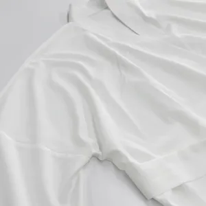 Dettaglio cardigan a portafoglio bianco tinta unita, tessuto setoso, stile minimalista.